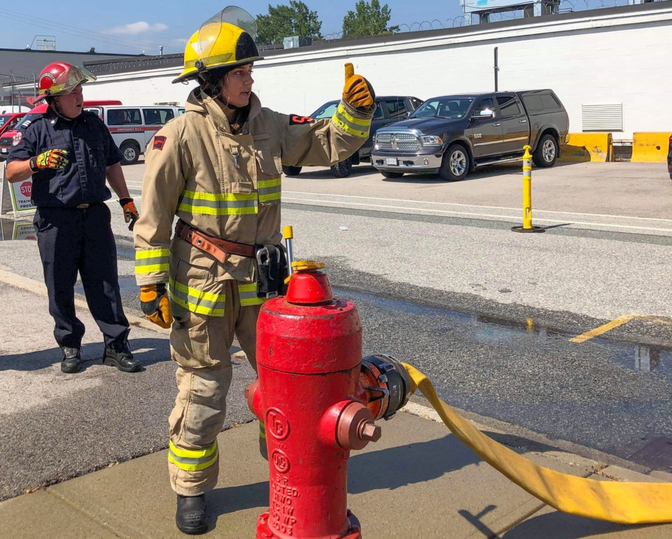 Kelsey Eckert attaches a hose to a fire hydrant during CampIgnite