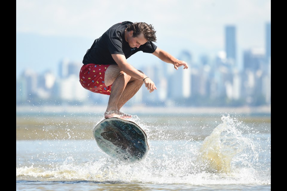Oscar Blyth an instructor with Kayotics Skim Board Camp shows off his skills at Spanish Banks East earlier this week. Photo Dan Toulgoet