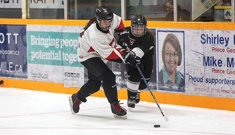 Team Black player Maria Ayre and Team White player Samantha Wiley battle for the puck on Friday night at Rolling Mix Concrete Arena during the first day of the Northern Capitals Female Midget AAA development camp. Citizen Photo by James Doyle