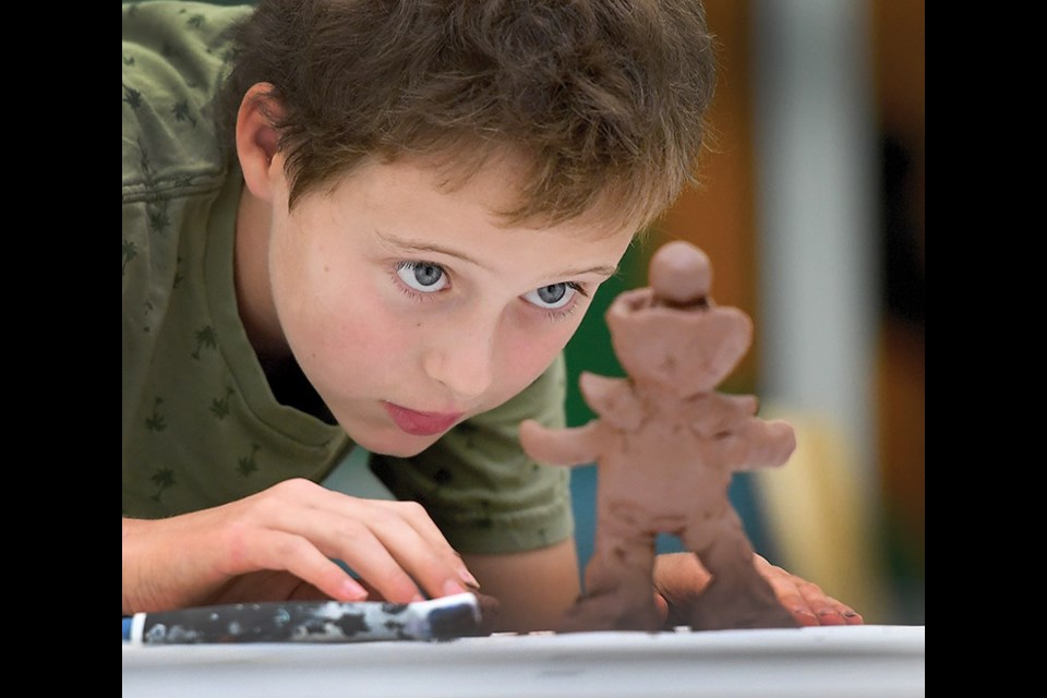 Murphy Crampton, 11, looks of his clay sculpture he was making during Creativity Camp at Two Rivers Gallery Monday morning. Local potter Ayla Davidson was teaching the students how to work with clay. Children in the one week class will be learning different ways to make abstract art. Citizen photo by Brent Braaten
