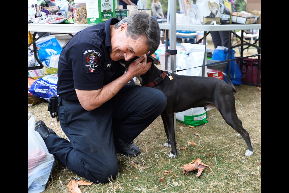 Phil Greene, an animal services officer with the City of New Westminster, catches up with Tucker at the community pet outreach event in Moody Park on Sunday.