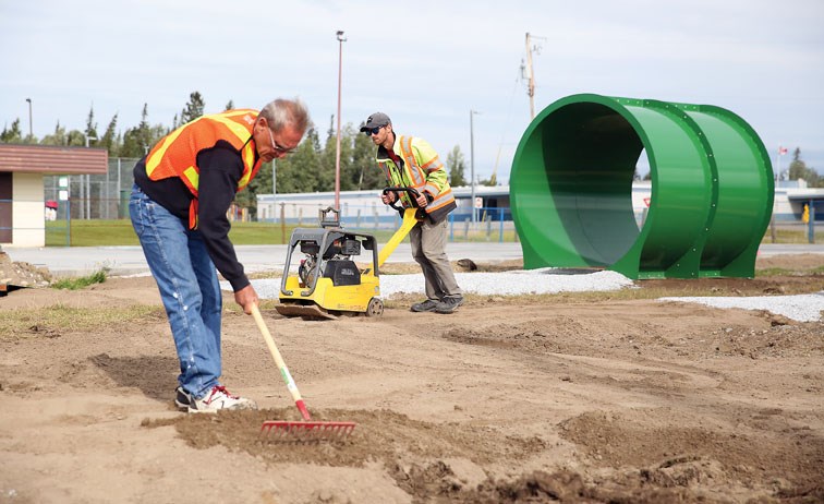 Jeff McLaren, left, and Brian Kuney, both with the Canadian Ramp Company, work on the Blackburn RE/MAX All Wheels Adventure Park on Wednesday morning. The park is situated between Blackburn Elementary School and Blackburn Community Hall and will feature a dirt and wood bike track, bike and skateboard ramps, rails, and public washroom facilities. Citizen Photo by James Doyle