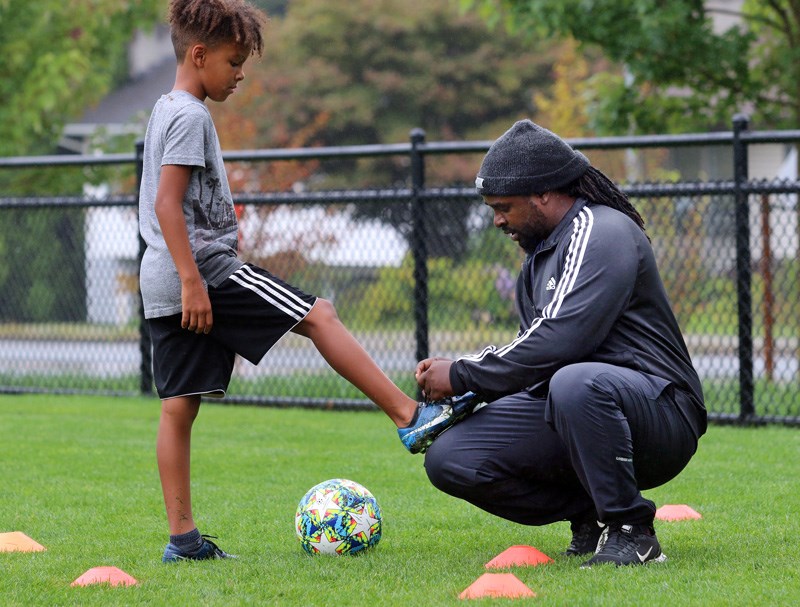 Robert Birungi gives instruction to children learning to play soccer at Victoria Park in Coquitlam. Recently, he was subjected to a racist tirade and now the Coquitlam community is mounting a campaign to support him.