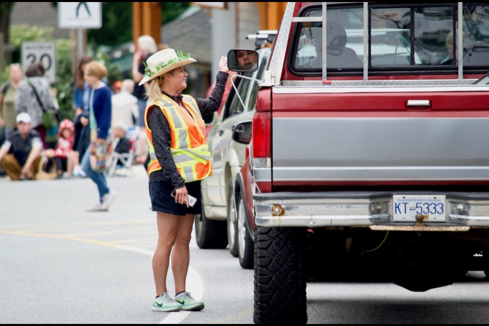 Traffic flagger Jewal Maxwell takes a moment to visit with folks in the ferry lineup before the parade.