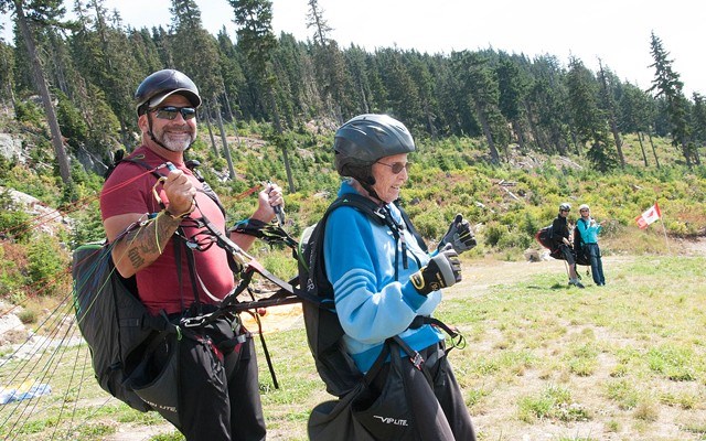 Guy Herrington and Jean Spierling prepare to go on Spierling’s first-ever paragliding flight at the