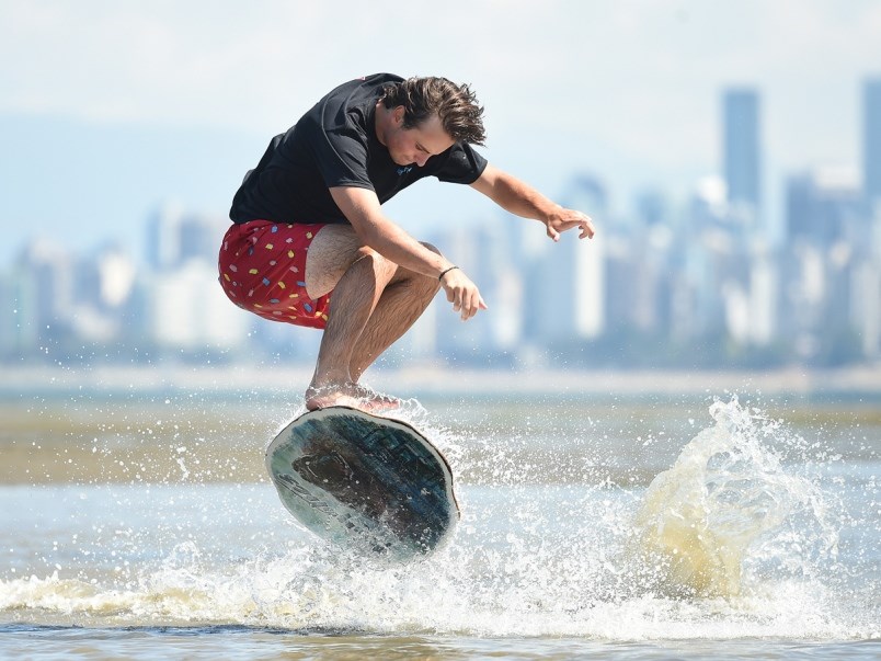 Oscar Blyth an instructor with Kayotics Skim Board Camp shows off his skills at Spanish Banks. Photo