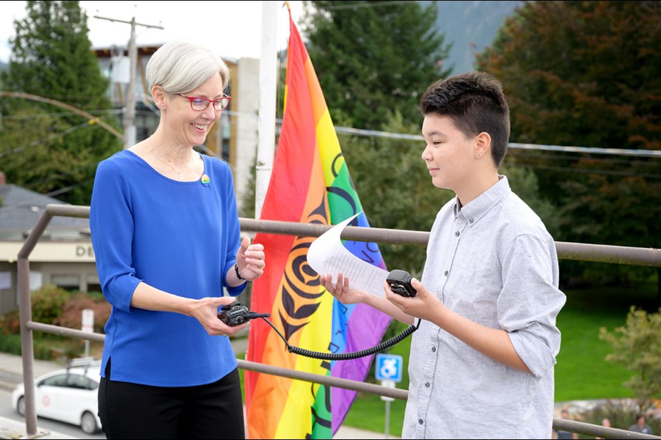 Pride Squamish member James Fujimagari reads a speech during the raising of the Squamish Pride flag ceremony, as Squamish mayor Karen Elliott looks on.