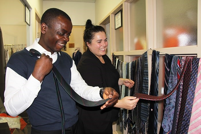 Working Gear operations manager Sarah Beley helps client Michael Olabode pick out a new tie. Photo E