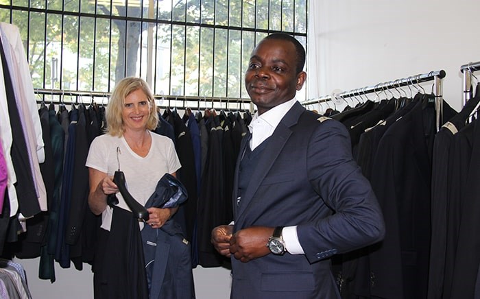 Joan Glover helps client Michael Olabode pick out a suit. Photo Elisia Seeber