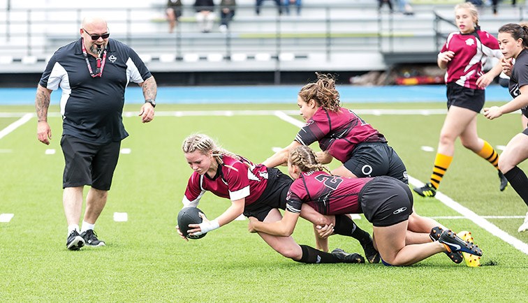 Players from the Williams Lake Rustlers (red/black) haul down a player from the Fort St. John Mini Macks on Sunday at Masich Place Stadium during the Prince George Junior Vixens Rugby Club’s home opener tournament. Citizen Photo by James Doyle