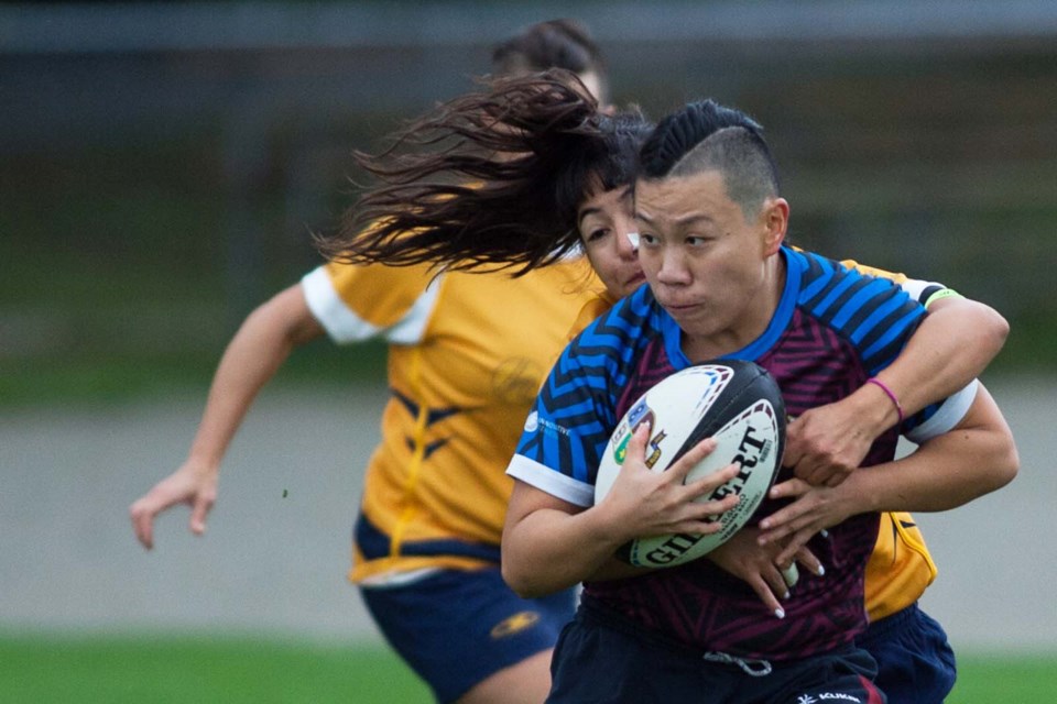 Looking for a long run is United Rugby Club’s Yvonne Lai, who is shadowed by a Scribes’ tackler in last Saturday’s 29-5 win at Hume Park.