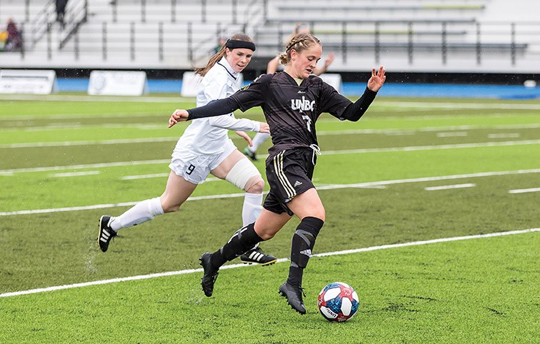 UNBC Timberwolves midfielder Paige Payne looks to make a play with the ball in front of Mount Royal University Cougars defender Quinn Hardstaff on Sunday afternoon at Masich Place Stadium. Citizen Photo by James Doyle