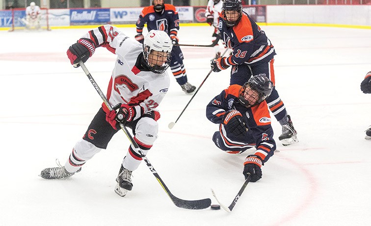 Cariboo Cougars forward Nico Myatovic stickhandles the puck around the outstretched stick of diving Thompson Blazers defender Cole Senum on Sunday morning at Kin 1. Citizen Photo by James Doyle