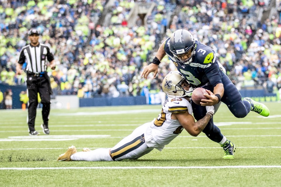 Seattle Seahawks quarterback Russell Wilson scores a 2-yard rushing touchdown against Saints cornerback Marshon Lattimore in the fourth quarter as the Seattle Seahawks take on the New Orleans Saints at CenturyLink Field in Seattle on Sunday.