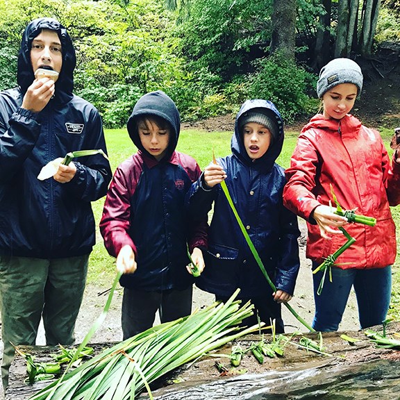 Tristan Savauge, Kai Norie, Grady and Ellie Brown — crafting cattail ducks for a cattail duck race at Squamish River Day in McNaughton Park on Sunday.