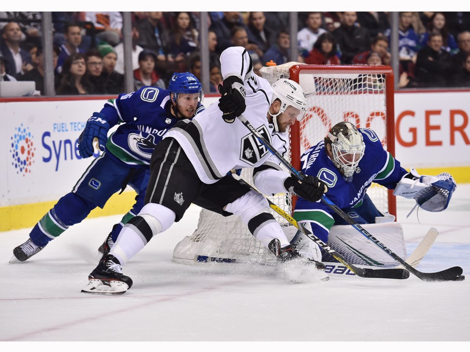 Kyle Clifford of the Los Angeles Kings tries to jam a puck past Jacob Markstrom of the Canucks.