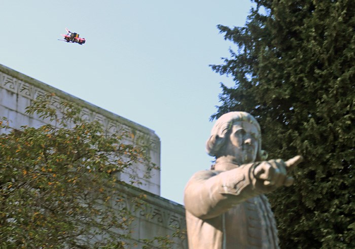 A drone flies behind the statue of George Vancouver at city hall ahead of the Global Climate Strike.