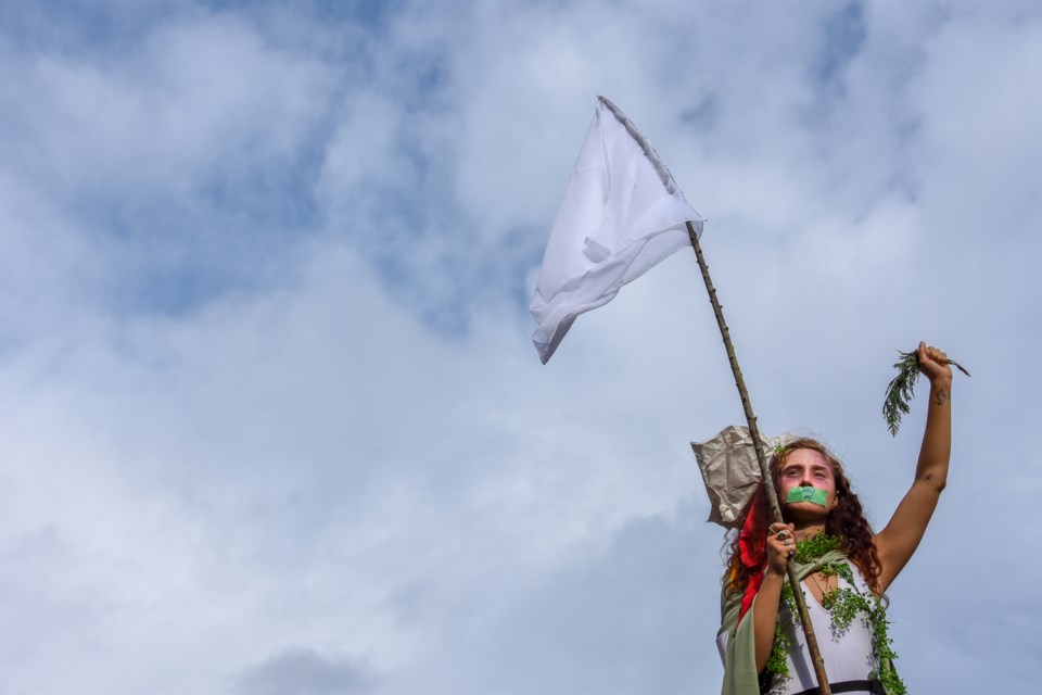 A demonstrator stands above a gathered crowd in downtown Vancouver during Friday's Global Climate Strike