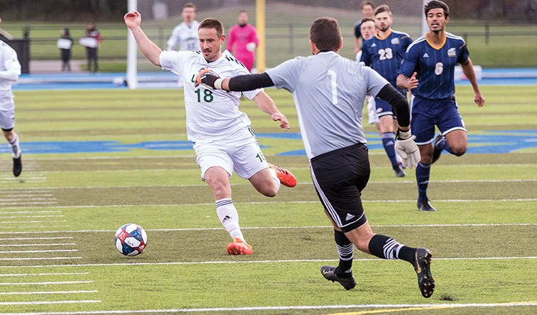 UNBC Timberwolves forward Stu Rowlands tries to get to the loose ball before UBC Thunderbirds goalkeeper Jason Roberts on Friday evening at Masich Place Stadium. Citizen Photo by James Doyle