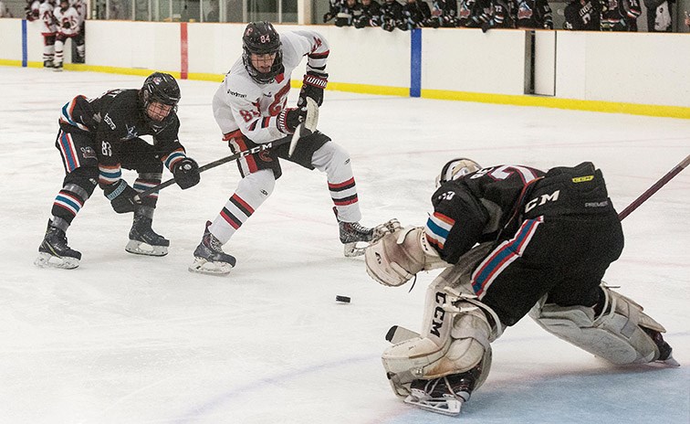 Cariboo Minor Midget Cougars forward Max Sandford breaks in alone while getting checked from behind by Okanagan Minor Midget Rockets defender Charlie Lockhart on Saturday evening at Kin 2. Citizen Photo by James Doyle