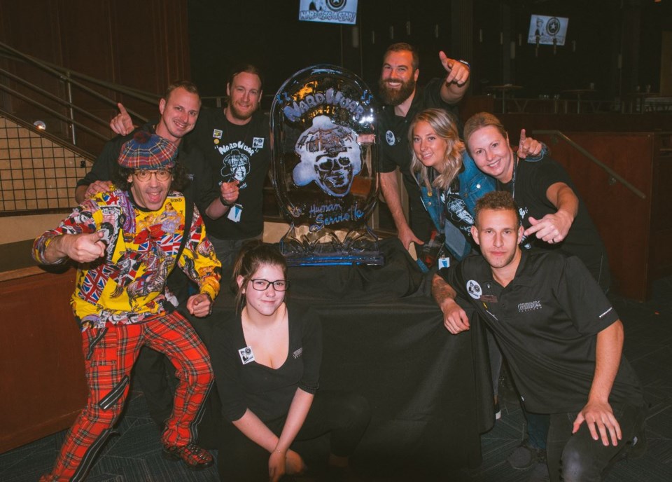 Nardwuar poses for a photo with staff of the Commodore and the ice sculpture they bought for him.
