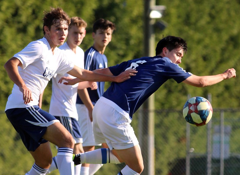 MARIO BARTEL/THE TRI-CITY NEWS
Archbishop Carney's Nick Pavicevic and Dawson Brown battle a Dr. Charles Best forward for control of the ball in the first half of their Fraser North Athletic Association senior boys' soccer match, Tuesday at Archbishop Carney secondary. The teams played to a 2-2 draw. Brown scored one of the Stars' goals, while Malcom Kengni scored the other. Erwin Perez scored both goals for the Blue Devils. "We showed we can compete at AAA today against a good team," said Stars' coach Mate Zvicer. "We knew we were going to be in for a tough game," said Blue Devils' coach Dave Jones.