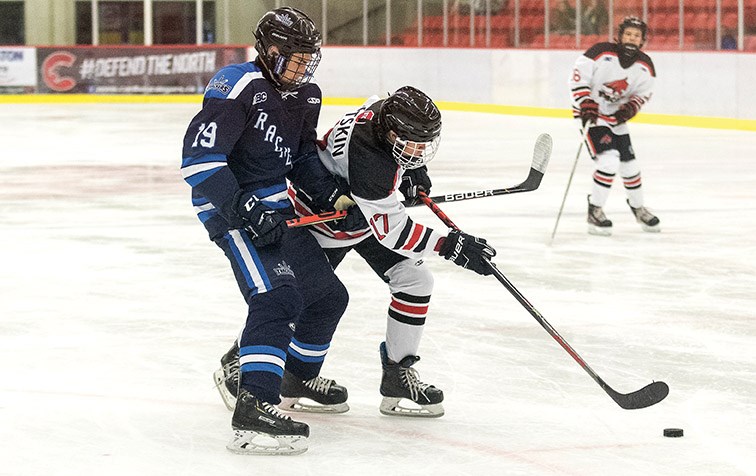 North Central Bobcats player Hunter Potskin tries to stick handle the puck while being checked by Northeast Trackers defender Jayden Whitford on Saturday evening at Kin 1 in exhibition Bantam Double-A action. Citizen Photo by James Doyle