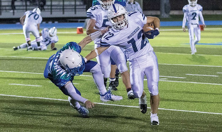 College Heights Cougars player Hayden Mathenson blocks the tackle of Kelly Road Roadrunners defender Darren Eikum on Saturday night at Masich Place Stadium in the first regular season game of the B.C. Secondary Schools Double-A Varsity football season. Citizen Photo by James Doyle