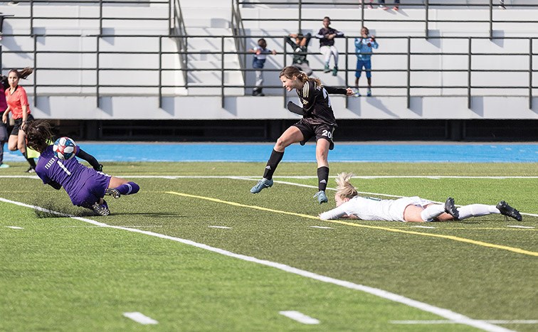 UNBC Timberwolves player Sofia Jones puts the ball into the net over UFV Cascades goalkeeper Jovan Sandhu on Sunday afternoon at Masich Place Stadium.