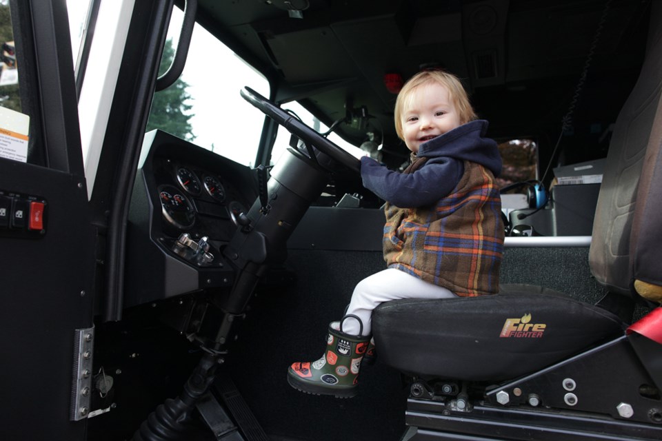 Sixteen-month-old Aspen Rupp looks good behind the wheel of a fire truck.
