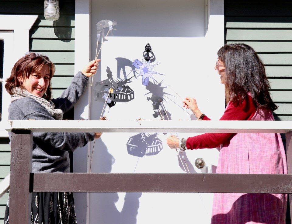 Daniella Sorrentino (left) and Liz Nankin (right) play with shadow puppets.