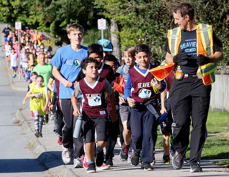 Led by Frank Pearse, the principal at Seaview elementary school in Port Moody, students from several Tri-City schools run to assemble at the office of the Terry Fox Foundation, where they donated more than $70,000 for cancer research last Friday.