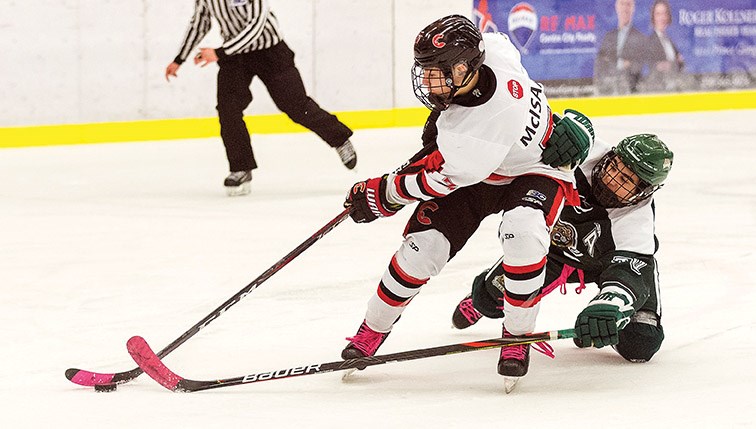 Cariboo Minor Midget Cougars player Brady McIsaac breaks in alone while being heavily checked by North Island Silvertips defender Kevin Okuma on Sunday morning at Kin 1. Citizen Photo by James Doyle