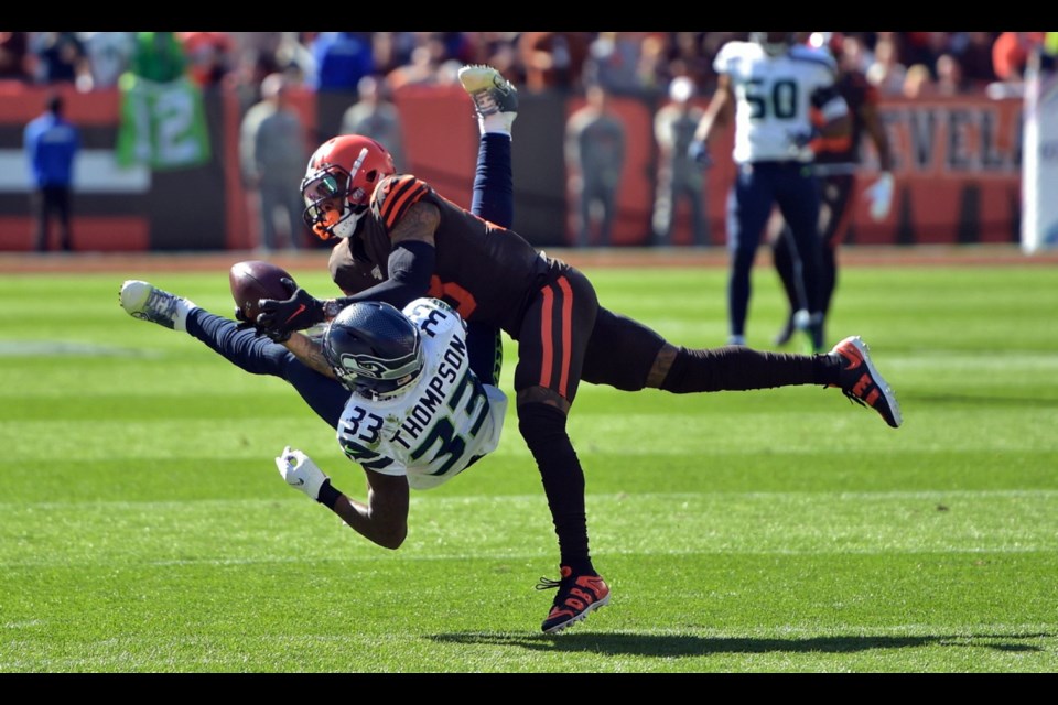 Cleveland Browns wide receiver Odell Beckham Jr. (13) catches a pass under pressure from Seattle Seahawks free safety Tedric Thompson (33) during the first half of Sunday's game in Cleveland.