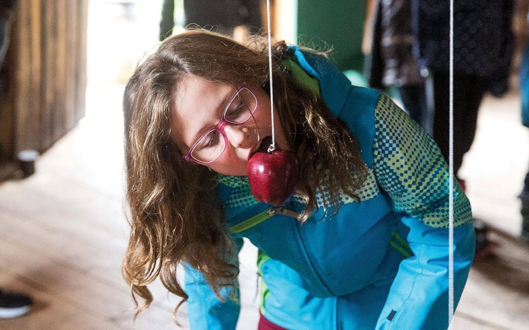 Nine-year-old Kassidy Heffernan attempts the apple bobbing on Monday during Huble Homestead’s Old-Fashioned Thanksgiving Celebration festivities. Citizen Photo by James Doyle