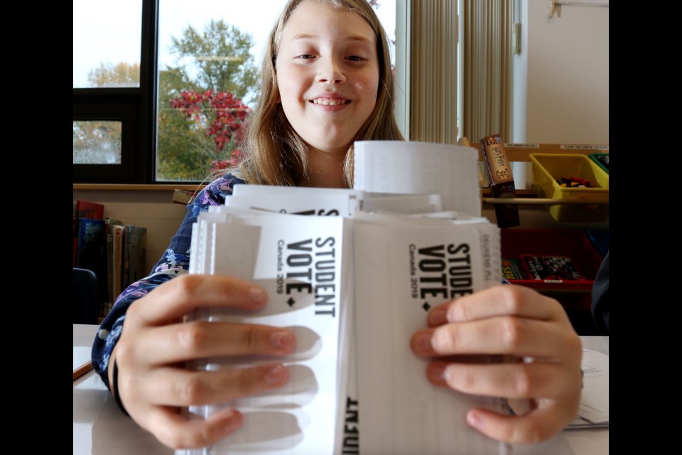 Larkin Ryshak, a Grade 6 student at Maillard middle school, prepares ballots for the school's mock election last Wednesday.