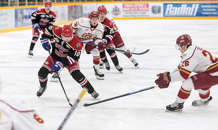 Prince George Spruce Kings forward Corey Cunningham goes in on net against the check of Chilliwack Chiefs defender Nathan Kelly on Saturday night at Rolling Mix Concrete Arena.