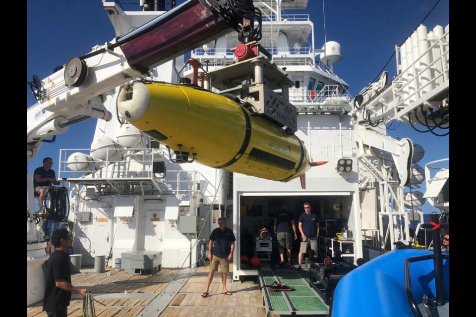 An autonomous underwater vehicle carrying sonar images of the Japanese aircraft carrier Akagi is loaded onto the research vessel Petrel.