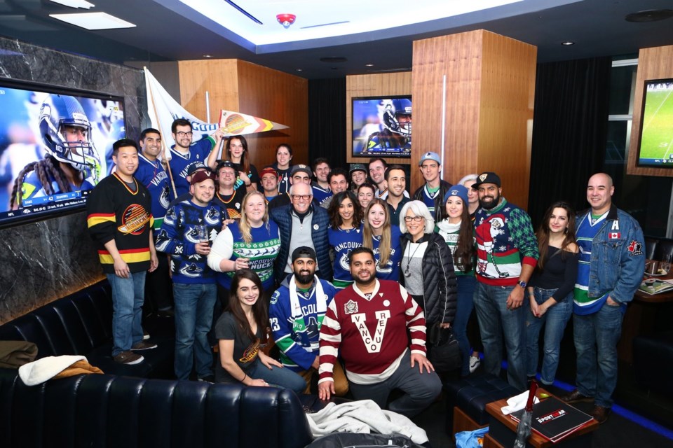 Tommy Larscheid (centre with glasses) stands among the Canucks fan group that shares his name and en