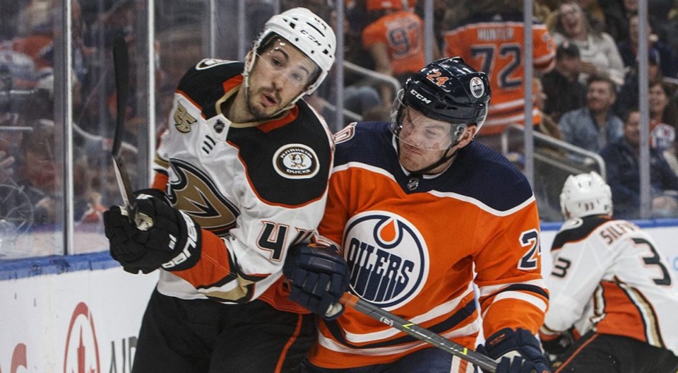 Michael Del Zotto of the Anaheim Ducks gets hit by Brad Malone of the Edmonton Oilers.