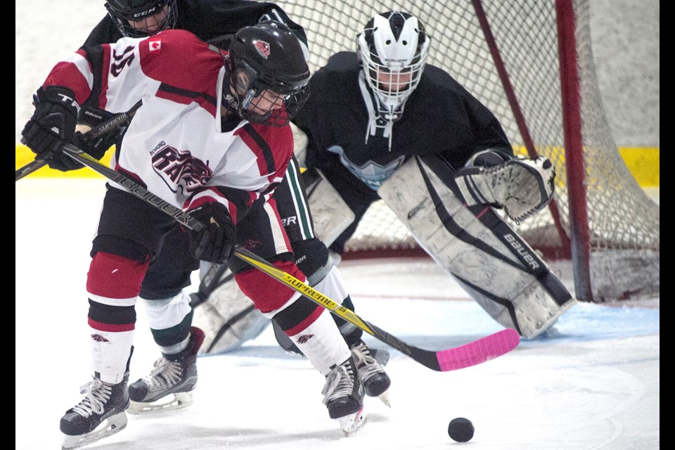 Richmond Ravens' Ashley Specht battles in front of the Sherwood Park net during round-robin action Saturday at the Seventh Annual Pacific Coast Female Rep Hockey Classic. The hosts won this game 3-1 and went on to capture the Midget Division title with a perfect five-game run.