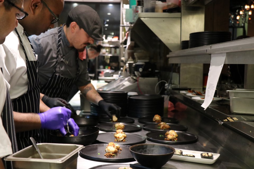 Piva chef Subraaz Abdullah, left, and El Santo executive chef Sam Fabbro work side-by-side plating the second of the seven-course dinner.