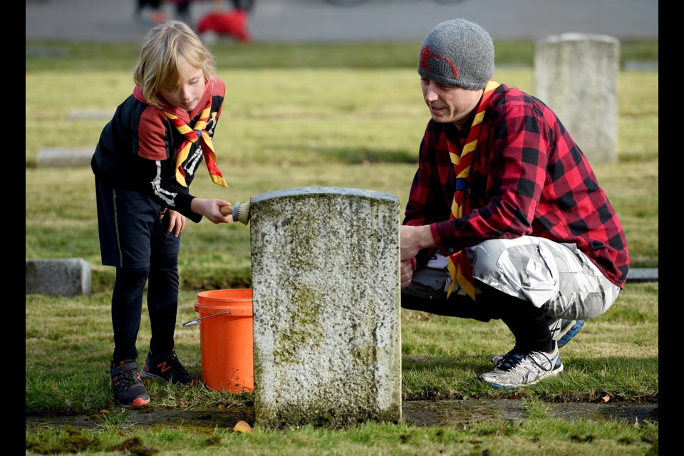 A time to share: Local students and community members helped the Society of the Officers of the Honourable Guard to clean hundreds of veterans' markers in Fraser Cemetery on Sunday, sharing stories along the way. Gary Carlson and seven-year-old Cooper of the beavers were among those taking part in the event.