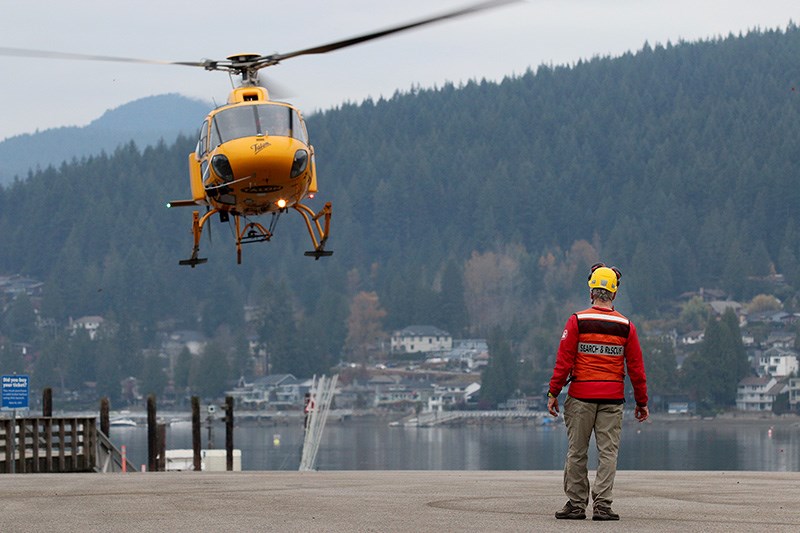 MARIO BARTEL/THE TRI-CITY NEWS
Garry Mancell, of Coquitlam Search and Rescue, guides a Talon helicopter in for a landing at the boat launch area in Port Moody's Rocky Point Park during an emergency preparedness exercise on Tuesday.