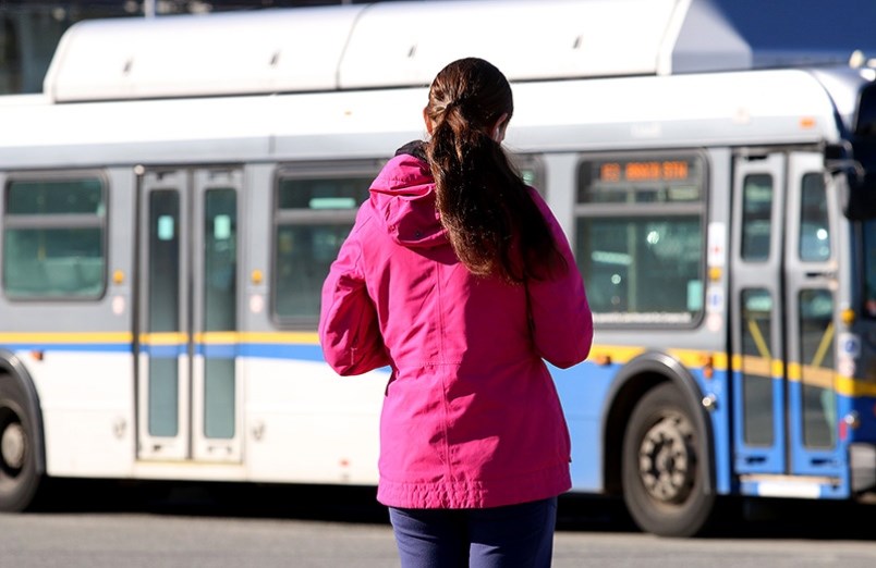 A rider waits for a bus in the Tri-Cities