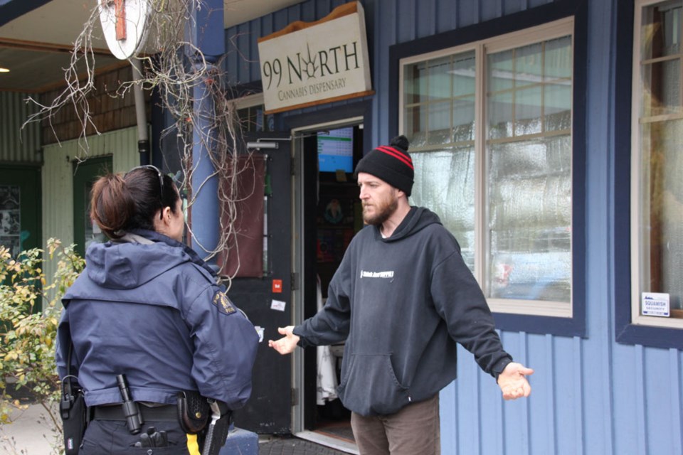 Bryan Raiser speaks with an RCMP officer as his store, 99 North, is closed in Squamish on Nov. 5.