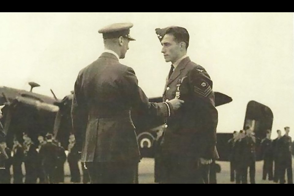 RCAF Sgt. Marcel Croteau, right, is awarded the Distinguished Flying Medal by King George VI in an August, 1944 ceremony.