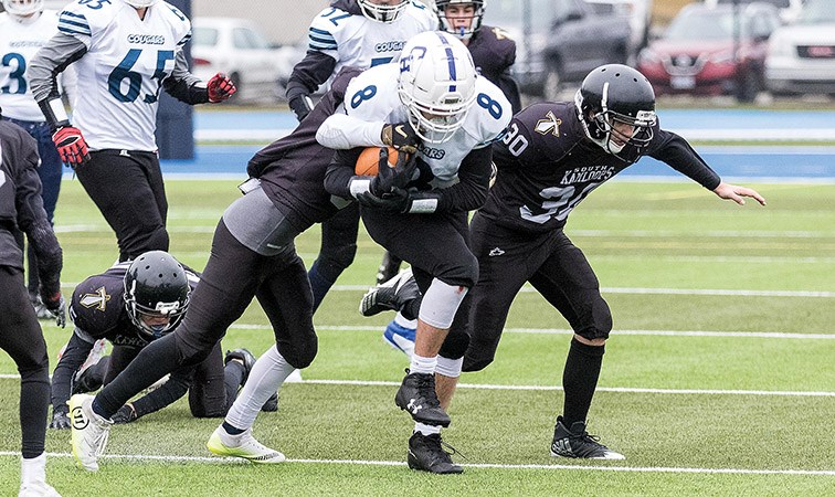 College Heights Cougars player Brayden Adams runs the ball down field against a pair of South Kamloops Titans defenders on Saturday afternoon at Masich Place Stadium. The two teams met in a B.C. Secondary Schools Junior Varsity quarter-final playoff game. Citizen Photo by James Doyle