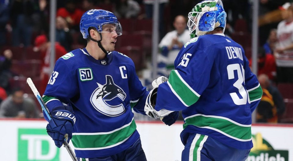 Bo Horvat congratulates Thatcher Demko on a win for the Vancouver Canucks.