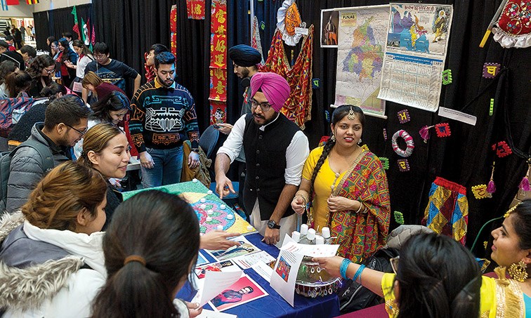 Students gather around the India booth on Wednesday during a Multicultural Day International Village at the Gathering Place in CNC that was part of the college’s International Education Week celebrations. Citizen Photo by James Doyle